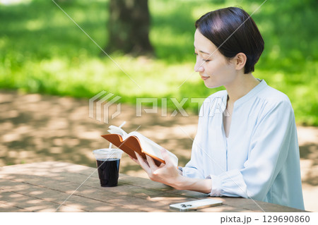 屋外で読書をする若い女性　ライフスタイルイメージ 129690860