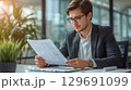 オフィスで書類を確認する男性ビジネスパーソン 129691099