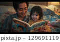 寝る前の読み聞かせを楽しむ父と娘の温かいひととき 129691119