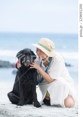 海で遊ぶ大型犬と飼い主 海で遊ぶ大型犬と飼い主 129691200