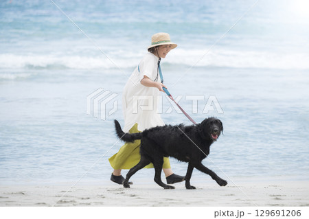 犬と海辺を走る人　アクティブな飼い主のイメージ 129691206