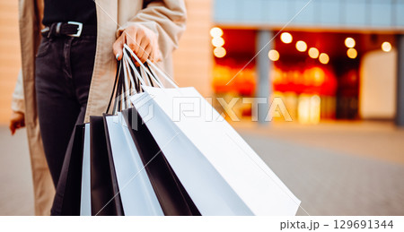 Young woman with shopping bags near mall. Spring Style. Consumerism, purchases, shopping, lifestyle 129691344