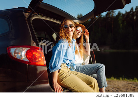 Smiling young woman have fun in the back seat of a car while traveling. Active lifestyle. Smiling young woman have fun in the back seat of a car while traveling. Active lifestyle. 129691399