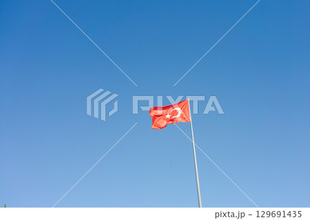 Red flag with a white star on it is flying in the sky 129691435