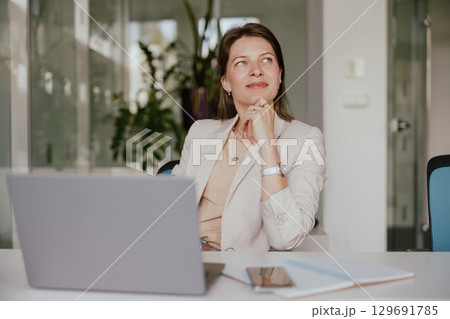 A Thoughtful and Ambitious Businesswoman Working Hard in a Modern Office Environment A Thoughtful and Ambitious Businesswoman Working Hard in a Modern Office Environment 129691785