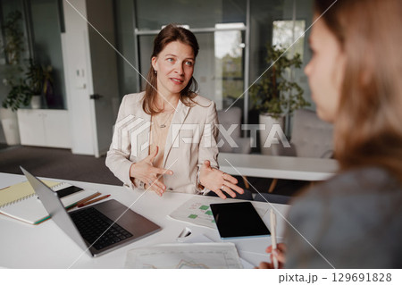 A Business Meeting Taking Place Among Professional Women Within a Modern Office Environment A Business Meeting Taking Place Among Professional Women Within a Modern Office Environment 129691828