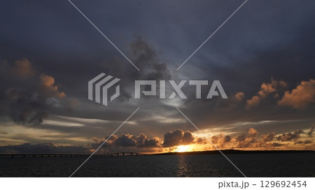 宮古島の空と海を染める夕日 伊良部大橋のシルエット 129692454
