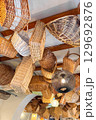 Interior ceiling of a rustic restaurant decorated with hanging wicker baskets and warm pendant lights. Cozy boho atmosphere 129692876