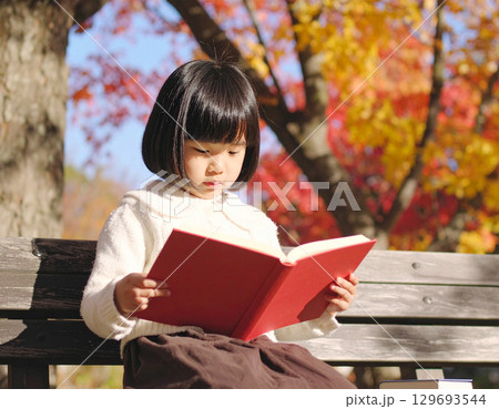 秋の公園で読書をする女子学生 129693544