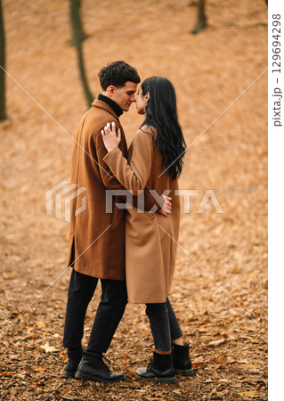 Young couple in love walking in the park on a autumn day. Enjoying time together. Young couple in love walking in the park on a autumn day. Enjoying time together. 129694298
