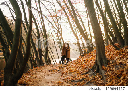 Young couple in love walking in the park on a autumn day. Enjoying time together. Young couple in love walking in the park on a autumn day. Enjoying time together. 129694337