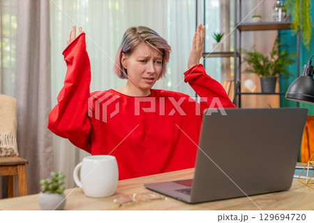 Woman emotionally arguing with laptop screen, gesturing angrily, irritated frustrated disagreement Woman emotionally arguing with laptop screen, gesturing angrily, irritated frustrated disagreement 129694720