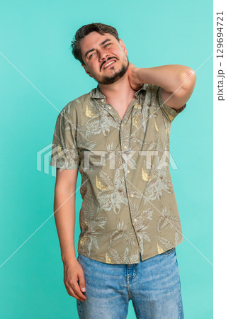 Adult man stretching back and massaging neck showing signs of fatigue muscle tension after long work Adult man stretching back and massaging neck showing signs of fatigue muscle tension after long work 129694721