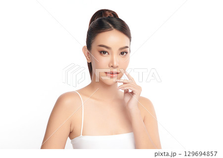 A beautiful young Asian woman with clean, fresh skin against a white background. Skincare, facial treatment, cosmetology, beauty, and spa. An elegant portrait of an Asian woman. A beautiful young Asian woman with clean, fresh skin against a white background. Skincare, facial treatment, cosmetology, beauty, and spa. An elegant portrait of an Asian woman. 129694857