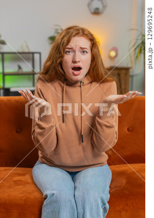 Young woman feeling hopelessness and loneliness, nervous breakdown, loses play sitting on sofa couch Young woman feeling hopelessness and loneliness, nervous breakdown, loses play sitting on sofa couch 129695248
