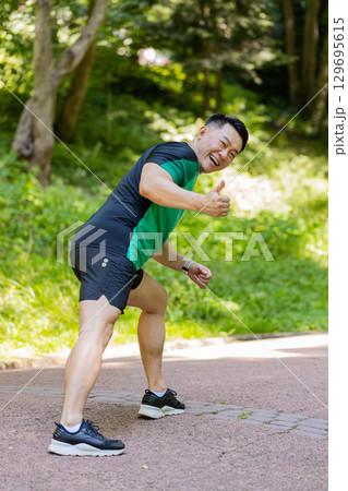 Athletic fitness sport motivated runner man training marathon run starting race showing thumb up Athletic fitness sport motivated runner man training marathon run starting race showing thumb up 129695615