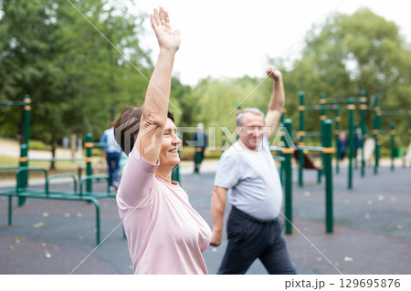 Sports pensioners do a warm-up on outdoor sports ground Sports pensioners do a warm-up on outdoor sports ground 129695876