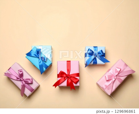 Pastel Wrapped Gifts with Ribbons on Beige Background for Celebration Holiday 129696861
