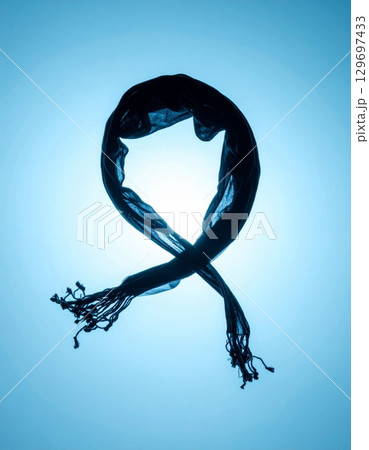 Elegant Dark Blue Scarf Silhouetted Against a Light Background Creates an Artistic Design 129697433
