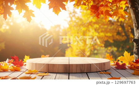 Autumn Leaves and Wooden Podium for Product Display Against a Bright Backdrop 129697763