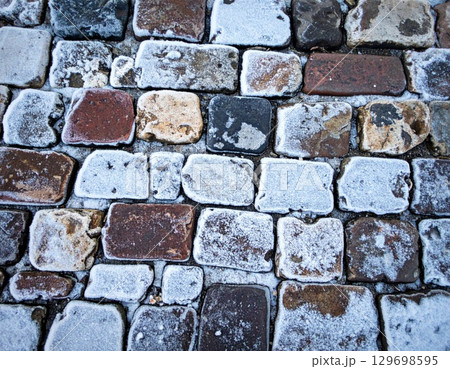 Close Up of a Cobblestone Street Pavement Texture with Weathered Stones 129698595