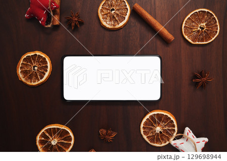 flat lay with smarthone and christmas decorations on walnut table flat lay with smarthone and christmas decorations on walnut table 129698944