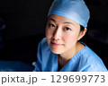 ブルーの手術着とサージカルキャップの女性外科医 129699773