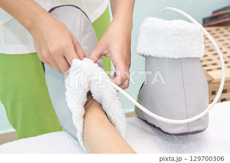 Foot therapy session with heated boot for relaxation and comfort Foot therapy session with heated boot for relaxation and comfort 129700306