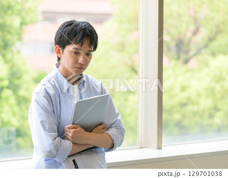 　沈んだ表情の大学生男子 129701038