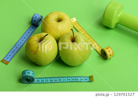Sports and health symbols. Pattern made of apples near barbell 129701527