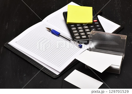 Office tools isolated on black wooden background, close up Office tools isolated on black wooden background, close up 129701529