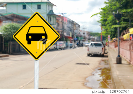 Yellow Road Sign with Car Symbol on Blurred Street Yellow Road Sign with Car Symbol on Blurred Street 129702764