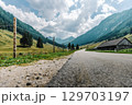 Summer mountain landscape with an asphalt road in the Solkpass pass in Austria. Panoramic view of alpine nature, green slopes and blue sky. 129703197