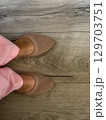 Stylish footwear worn with pastel pants on a wooden floor in a bright indoor setting 129703751