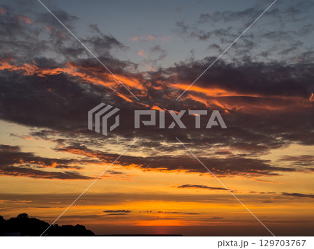 Stunning sunset over the horizon with vibrant colors reflecting on the clouds 129703767