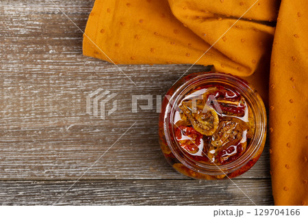 Dried cherry tomatoes in oil with herbs, flat lay. 129704166