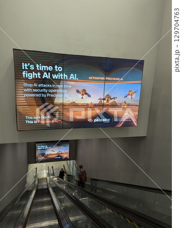 Gary Reed International Airport, Las Vegas, Nevada, USA - August 3, 2024: Escalator with advertising boards at the exit of the airport. 129704763