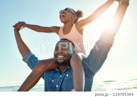 Summer, beach and girl on shoulder of father enjoying holiday, vacation and freedom on weekend. Black family, travel and happy dad and child smile on adventure for bonding, relaxing and fun by ocean 129705364