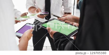 Hands, green screen and technology with a business team in studio isolated on a white background for communication or networking. Tablet, phone and mockup with an employee group on blank space Hands, green screen and technology with a business team in studio isolated on a white background for communication or networking. Tablet, phone and mockup with an employee group on blank space 129705380