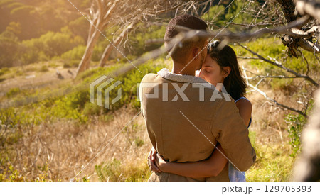 Nature, love and a couple hugging or kissing outdoor while sharing an intimate moment together in summer. Field, countryside and kiss with a man and woman bonding in sweet embrace outside with mockup 129705393