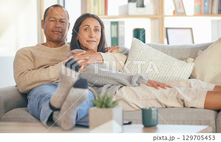 Portrait, love and senior couple on sofa, relax and in living room for bonding, romance and weekend break. Romantic, old man and mature woman on couch in lounge, loving and enjoy retirement together 129705453