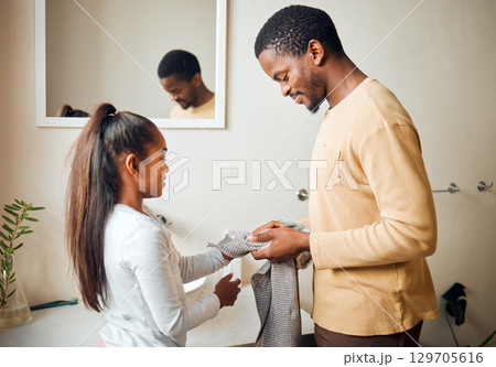 Black family, children or cleaning with a father and daughter in the bathroom of their home to dry hands. Kids, love and hygiene with a man and girl in a house for their morning routine together 129705616