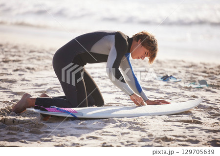 Fitness, beach and man waxing his surfboard before a sport competition, practice or training. Sports, surfing and male surfer preparing for a water workout or exercise in the ocean in Australia. 129705639