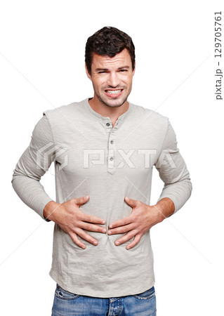 Hungry, sick and portrait of a man with a stomach problem isolated on a white background in studio. Stress, pain and person with a stomachache, abdominal pain or painful ibs on a studio background Hungry, sick and portrait of a man with a stomach problem isolated on a white background in studio. Stress, pain and person with a stomachache, abdominal pain or painful ibs on a studio background 129705761