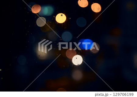 Bokeh, night and light on a window with water drops, liquid or moisture against a dark abstract background. Blurred lights, colorful and rain drop or splash on glass for city view during rainy season Bokeh, night and light on a window with water drops, liquid or moisture against a dark abstract background. Blurred lights, colorful and rain drop or splash on glass for city view during rainy season 129706199