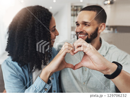 Love, heart hand sign and happy couple enjoy quality time together, bonding and relax on home living room sofa. Eye contact, emoji gesture and marriage people, man or woman smile in good health 129706232