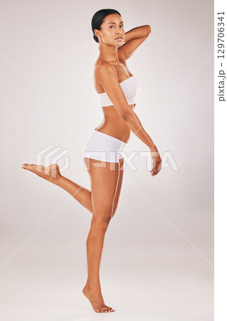 Portrait, body and balance with a model black woman in studio on a gray background for natural beauty. Fitness, wellness and underwear with an attractive young female posing to promote health 129706341