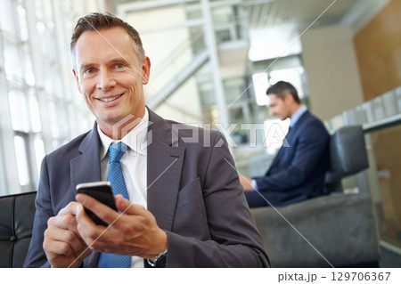 Portrait, happy or business man with phone in office for motivation, company research or website review. Manager or CEO with smartphone in hotel lobby for social network, internet or mobile app 129706367