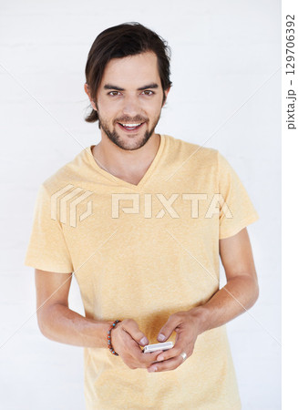 Portrait, mobile and phone of a man on technology typing a cellphone text on social media in white background. Online conversation, model and smile of vertical person with mobile phone texting app 129706392