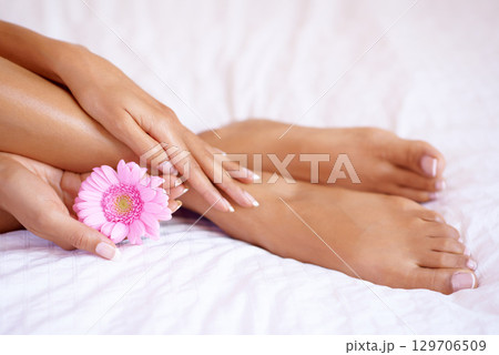 Pedicure, feet and a flower with a woman on a bed for luxury skincare, dermatology and wellness. Toes and hands of beauty model for self care, floral cleaning and cosmetics to relax and shine 129706509